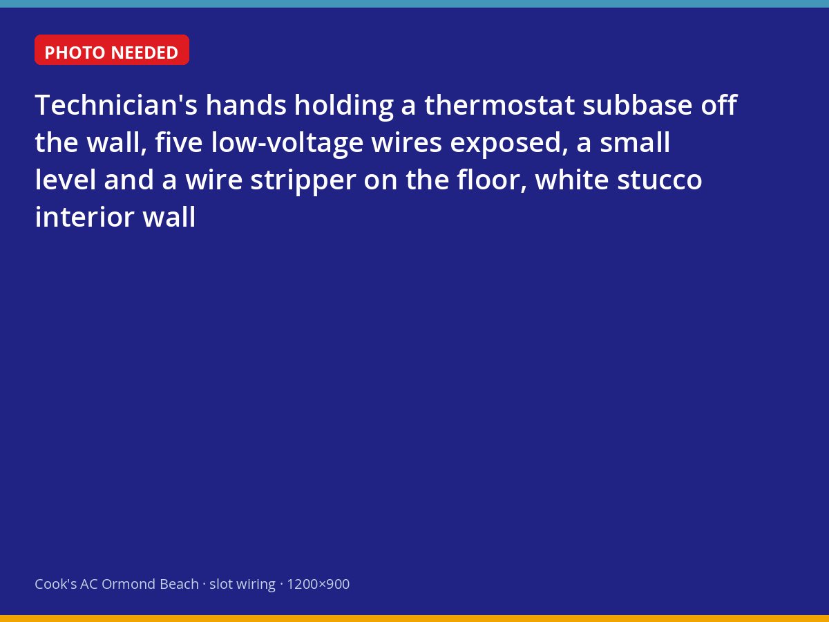 Technician checking low-voltage thermostat wiring at the wall plate